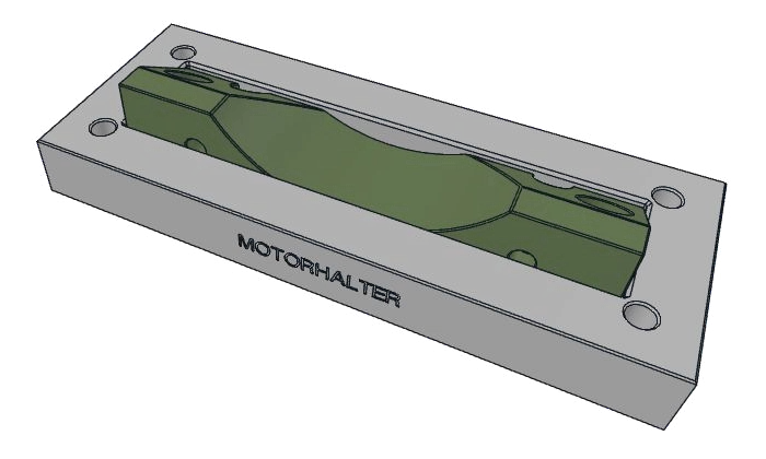 The green motor bracket sitting in the fixture made with YuvaForm